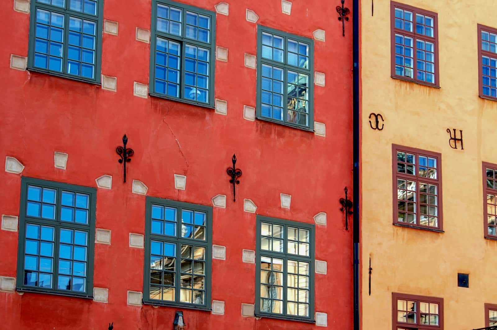 Fasader med fönsterrader i rött och ockra
